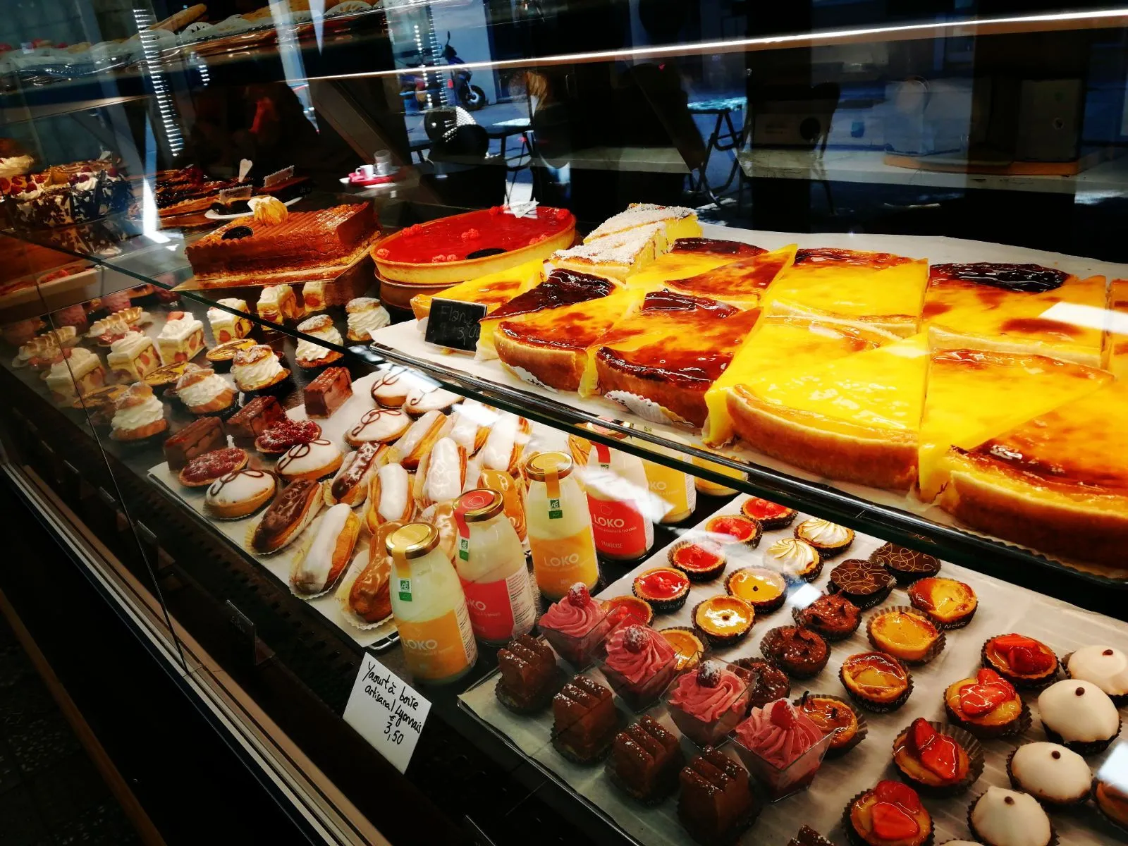 Vitrine de flans pâtissiers, tartes aux fruits et éclairs
